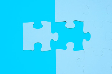 LAST PIECE OF THE PUZZLE. BUSINESS CONCEPT. BLUE BACKGROUND. TOP VIEW.
