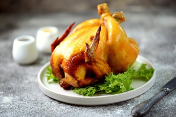 Grilled whole chicken on a gray background.