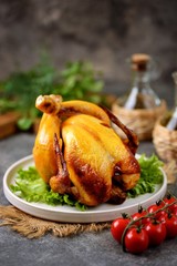 Grilled whole chicken on a gray background.