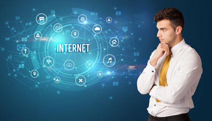 Businessman thinking in front of technology related icons and INTERNET inscription, modern technology concept