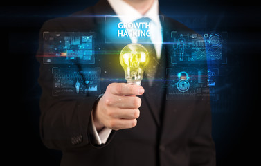 Businessman holding lightbulb with GROWTH HACKING inscription, online security idea concept