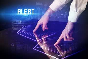 Hand touching digital table with ALERT inscription, new age security concept