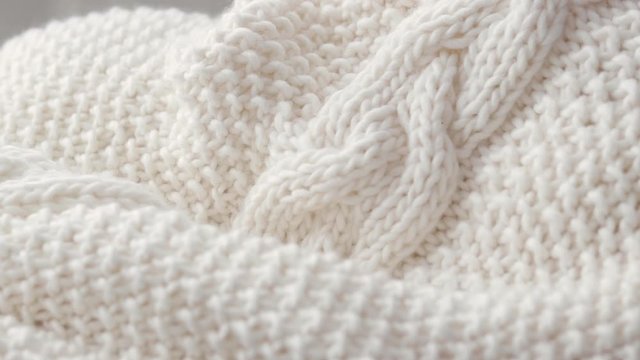 Detail of white hand-woven blankets that are placed on a chair.