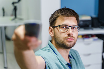 Caucasian man with eyeglasses using remote control at home