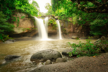 A terrific waterfall with severe water stream down from high cliff, surrounded by greenery rainforest jungle environment. Photo taken with long exposure for smoothed water line. 