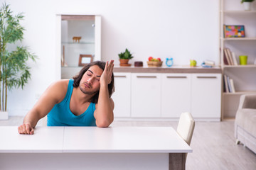 Young man waking up at home