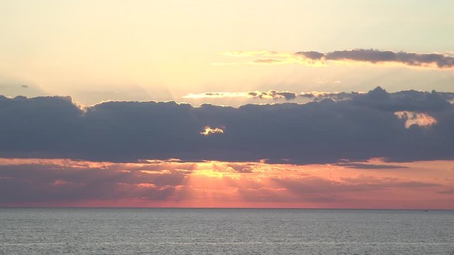 Sun behind cloud sunset sun rays glimmer, gleam, shine through clouds and water waves. silver lining. Lake Huron static