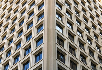 Looking up at skyscraper exterior design. Abstract view of windows, mirror reflection and detail architecture close-up