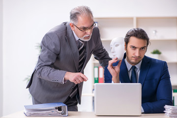 Old boss and young male employee wearing masks