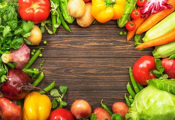 Assortment of fresh vegetables on frame wooden table background. Healthy organic food grocery concept. Copy space