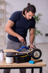 Obraz premium Young male repairman repairing skateboard