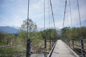 Obraz premium Wooden bridge over the river and beautiful summer landscape of Japanese alps in Hakuba, Japan