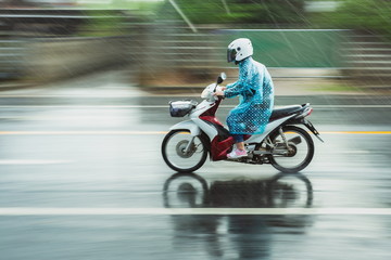 Motorcycle raincoat In the rain,people drive motorbike in rain day,motion blur of rush on running...