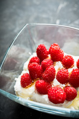 Healthy and tasty breakfast with curd, sour cream, raspberry and honey. Selective focus.