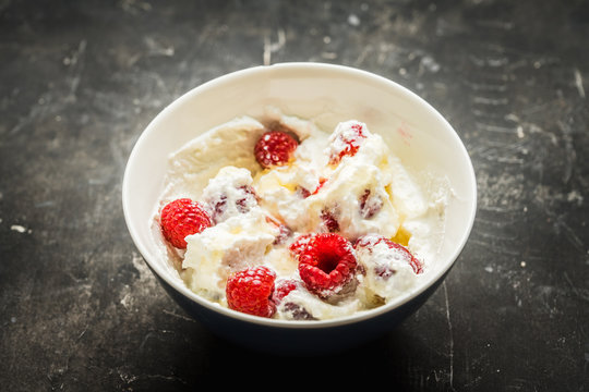 Healthy and tasty breakfast with curd, sour cream, raspberry and honey. Selective focus.