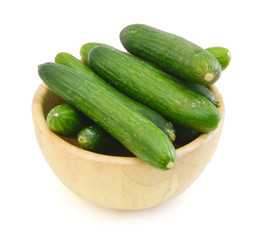 fresh cucumbers in wooden bowl on white