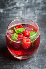 Raspberry and mint cocktail in glass on the rustic background. Selective focus. Shallow depth of field.