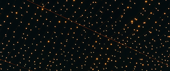 Many lightbulbs hanging on cable as garland decorative isolated on dark night sky background