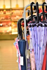 Umbrellas of different colors and designs on display at a convenient store