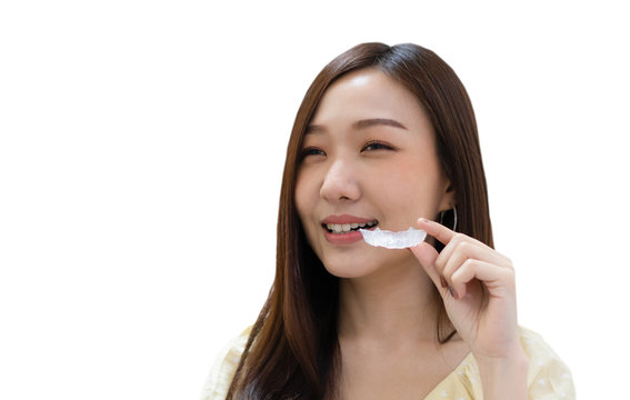young asian woman showing retainer after getting braces. dentist and healthcare concept