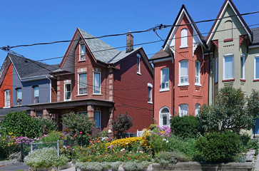 Street with colorfuly painted old semidetached houses with front gardens