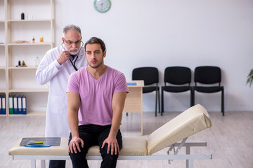 Obraz premium Young male patient visiting old male doctor