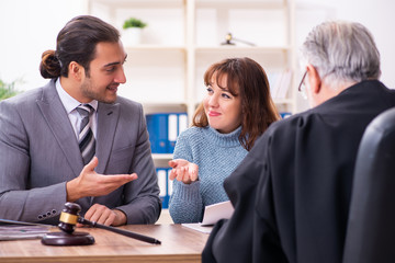 Young woman in courthouse with judge and lawyer