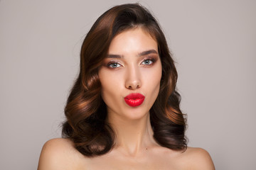 Portrait of beautiful brunette woman with retro hair style and makeup. Red lipstick and short hair