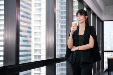 Business Lady officers or businesswoman smart posing standing while idea thinking with drink hot coffee in the morning in office