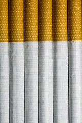 Tobacco cigarettes standing vertically on a table
