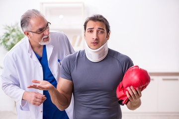 Young injured boxer visiting old doctor traumatologist