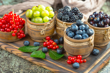 Ripe summer berries in a composition, on an old background.