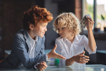 Red-haired boy asking money from his friend