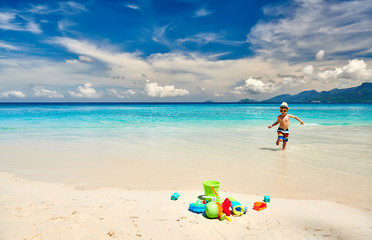 Three year old toddler playing on beach - 371715143