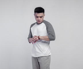 Young handsome man wearing raglan t-shirt with grey and white color isolated on background