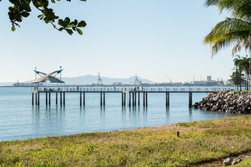 Fishermen on the jetty on The Strand beach with port behind, Townsville
