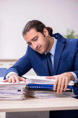 Young male employee unhappy with excessive work