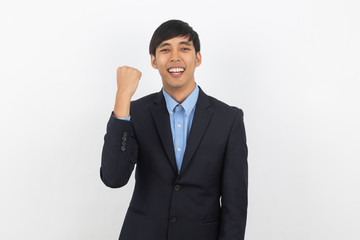 Excited young handsome asian business man raising his fists with smiling, celebrating success isolated on white background.