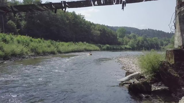 River kayaking under an old wooden bridge on Kolpa river in Slovenia. 4K