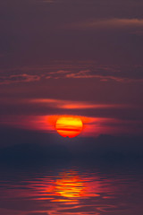 Sunset sky with cloud and silhouette mountain at the lake.