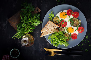 English breakfast - fried eggs, tomatoes and eggplant. American food. Top view, overhead, copy space