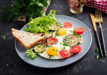 English breakfast - fried eggs, tomatoes and eggplant. American food.