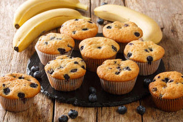 Homemade diet muffins with blueberries and bananas close-up on a slate board on the table....