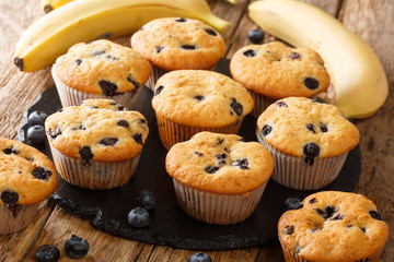 Freshly baked muffins with blueberries and bananas close-up on a slate board on the table. horizontal