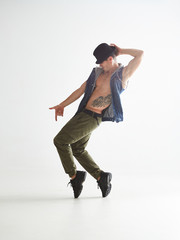 Young man dancer in hat dancing moonwalk in studio isolated on white background. Dance school poster