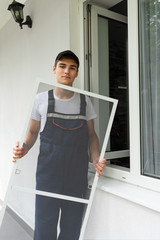 Construction worker sets mosquito net on a plastic windows