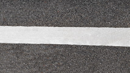 Fototapeta premium White paint line on asphalt road surface, with gray color guidelines on street, close up texture background concept, countryside Thailand.