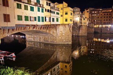 Ponte Vecchio over Arno River panorama in Florence Italy at night.