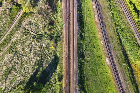 Train tracks with grass and trees, top view. Aerial view of railways