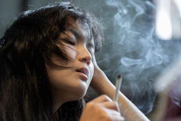 Asian girl smoking and feeling be absent-minded